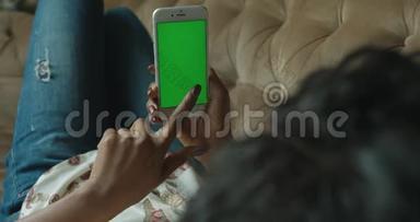 美国黑人妇女躺在沙发上用<strong>绿色</strong>手机<strong>上网</strong>后的特写镜头